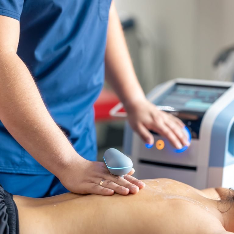 Doctor using machine to treat the back of a patient, T-CaRe technology, Resistive and Capacitive therapy.
